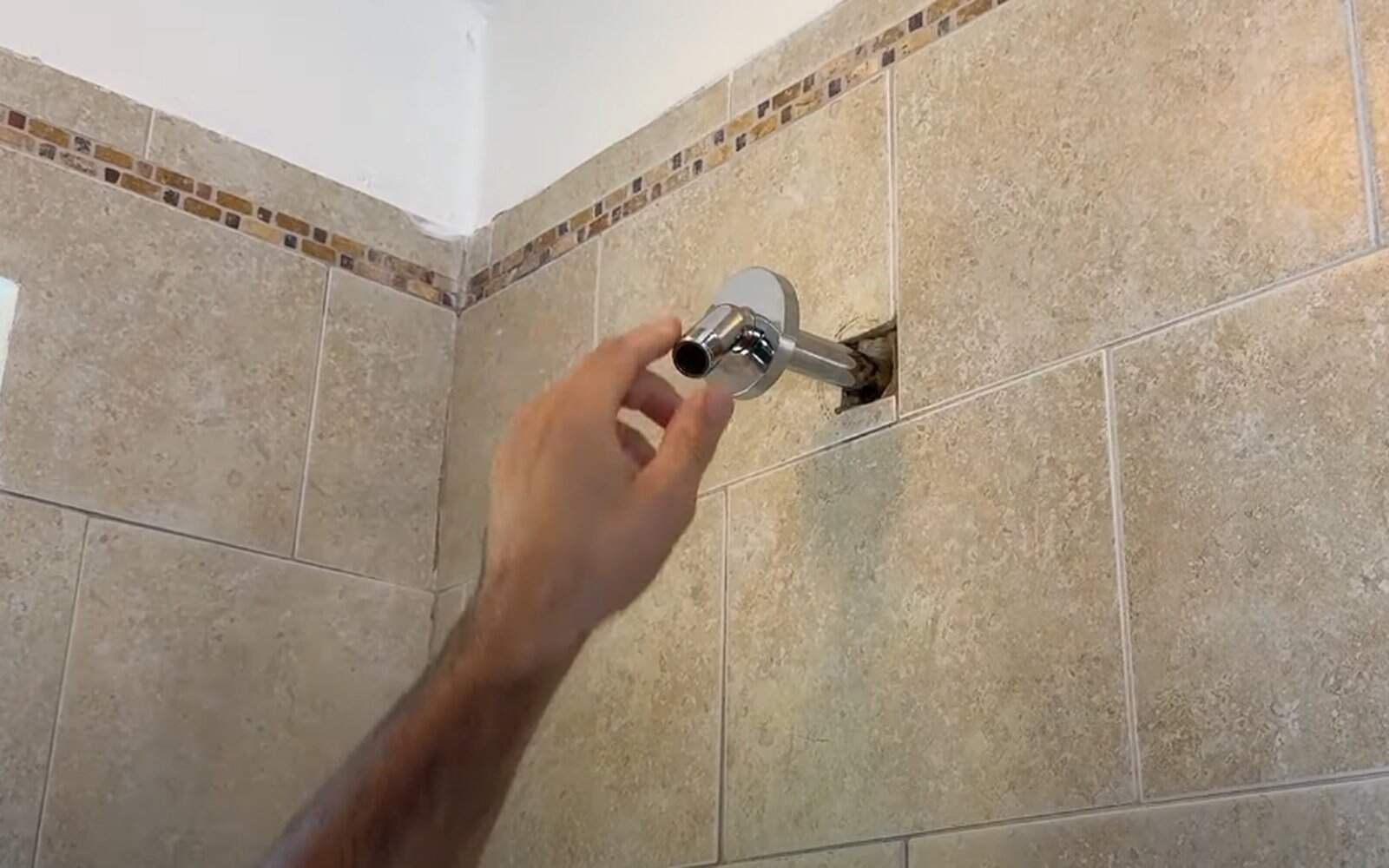 Screw arm into wall pipe clockwise by hand until snug